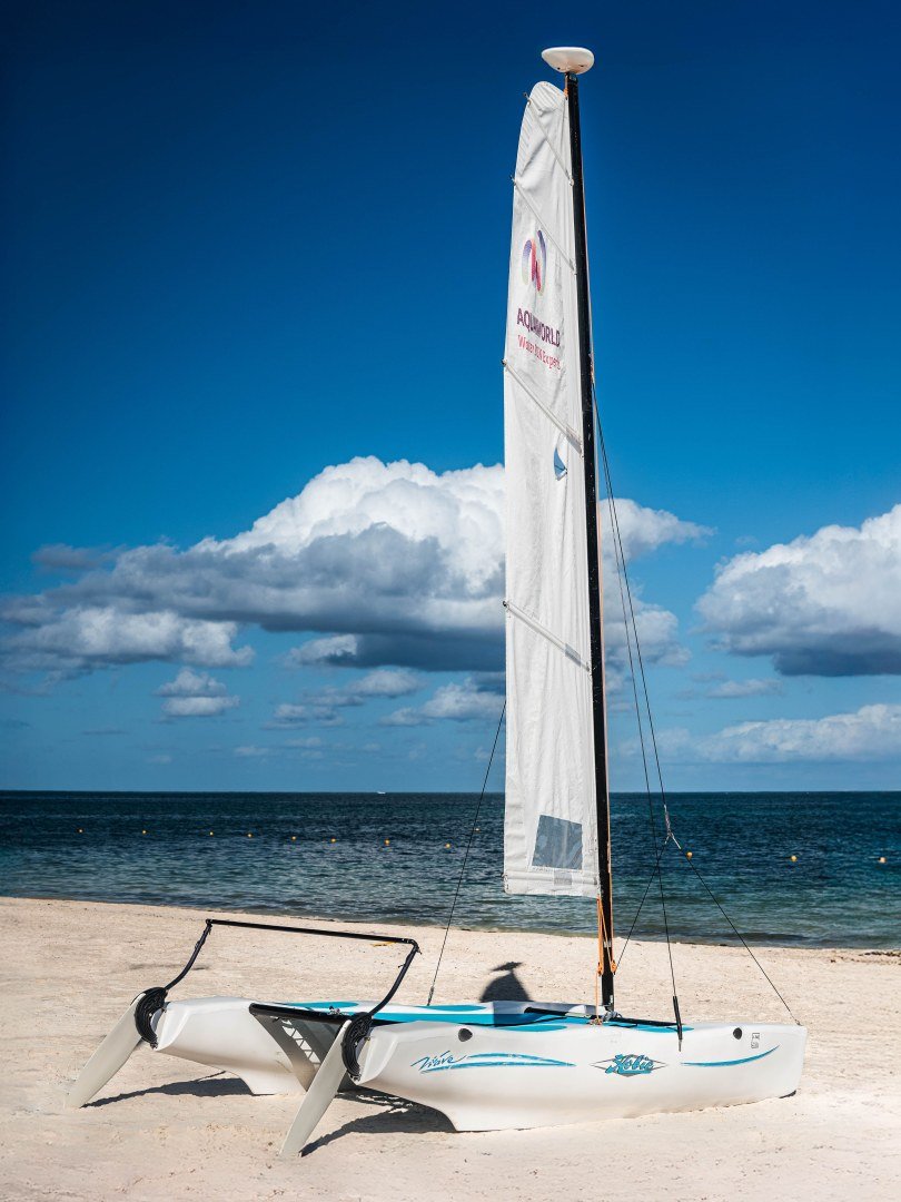 white-catamaran-on-sand-beach-blue-sky-ocean